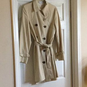 Tan double breasted trench coat.